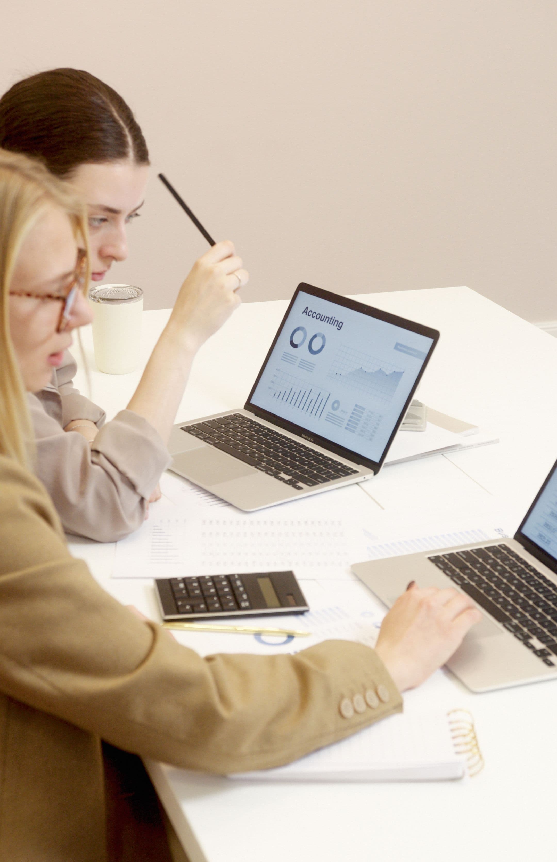 Two colleagues reviewing an accounting dashboard on a laptop